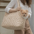 model carrying a beige pet bag over her shoulder, with a Pomeranian inside