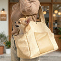 women holding small dog carrier with a dog in it