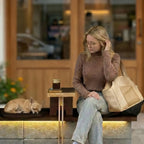 women holds a small dog carrier and watcher chihuahua sleeping