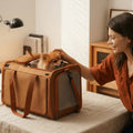 A model is petting a puppy inside a pet carrier